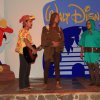 Tre persone recitano su un palco con sfondo Disney.