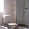 Bagno con doccia e sanitari bianchi.
