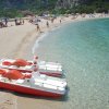 Spiaggia con pedalò e mare cristallino.
