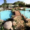 Piscina con piante tropicali e ponticello.