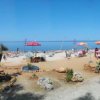 Una spiaggia con ombrelloni e montagne sullo sfondo.
