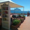 Libreria all'aperto con vista mare e tavolini sotto un gazebo.