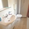 Bagno con lavabo, wc e doccia, pavimento in legno chiaro.