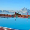 Piscina con vista mare e montagne in lontananza.