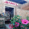 Esterno di un piccolo negozio di alimentari con grandi fiori rosa.