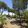 Un parco giochi all'aperto con scivolo blu e vegetazione rigogliosa.
