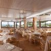 Ristorante con tavoli apparecchiati e ampie finestre.