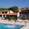 Piscina con getto d'acqua e lettini bianchi.