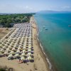 Una spiaggia con file di ombrelloni e mare azzurro.