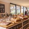 Buffet colazione con pane, dolci e affettati in una sala luminosa.