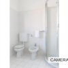 Bagno con wc, bidet e cabina doccia, tutto bianco.