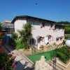 Edificio rosa con giardino fiorito e vialetto.