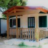 Una casetta con veranda in legno tra gli alberi.