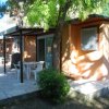 Bungalow con patio e tavolo all'aperto, circondato da alberi.