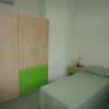 Camera da letto con letto singolo e mobili verdi.