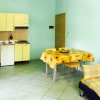 Cucina moderna con tavolo giallo e divano a quadri.