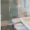 Bagno moderno con doccia in vetro, WC e bidet su pavimento effetto legno.