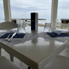 Tavolo apparecchiato per due in un ristorante con vista sul mare.