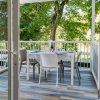 Tavolo apparecchiato su una veranda con vista su alberi verdi.