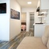 Interno con cucina, soggiorno e TV a parete.