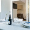 Tavola apparecchiata con vista su cucina moderna.