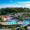 Un complesso turistico panoramico con piscine e vegetazione.