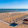 Spiaggia con ombrelloni chiusi gialli e blu.