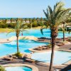 Piscine contornate da palme e mare.