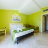 Camera da letto luminosa con pareti verdi e un letto matrimoniale.