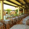 Ristorante all'aperto con tavoli apparecchiati bianchi.