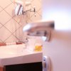 Lavandino con accessori in bagno piastrellato.