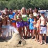 Gruppo di persone intorno a un vulcano di sabbia.