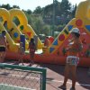 Bambini giocano su gonfiabile colorato all'aperto.