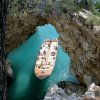 Barca sotto un arco di roccia naturale.