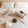 Letto con cuscini bianchi, asciugamani e decorazioni marine.