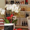 Fiori bianchi in un ristorante con vini sugli scaffali.