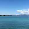 Vista di un lago con montagne e cielo blu.