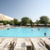 Piscina all'aperto con lettini e ombrelloni.