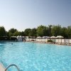 Piscina grande all'aperto con alcune persone.