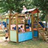 Bambini giocano su una struttura in legno.