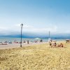 Spiaggia con persone al sole e mare calmo.