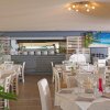 Ristorante con tavoli apparecchiati e decorazioni verdi.