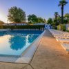 Piscina vuota al tramonto con lettini bianchi.
