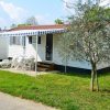 Una casa mobile bianca con verande su un prato verde.
