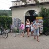 Persone camminano vicino a un edificio con cartoline.