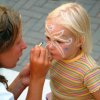 Bambina fa pittura facciale da un'artista.