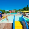 Piscina all'aperto con bambini e scivolo.