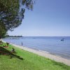 Spiaggia erbosa con vista sul lago e barche.