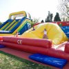 Bambini giocano su gonfiabili colorati in un parco.
