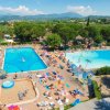 Piscine affollate e bagnanti prendono il sole.